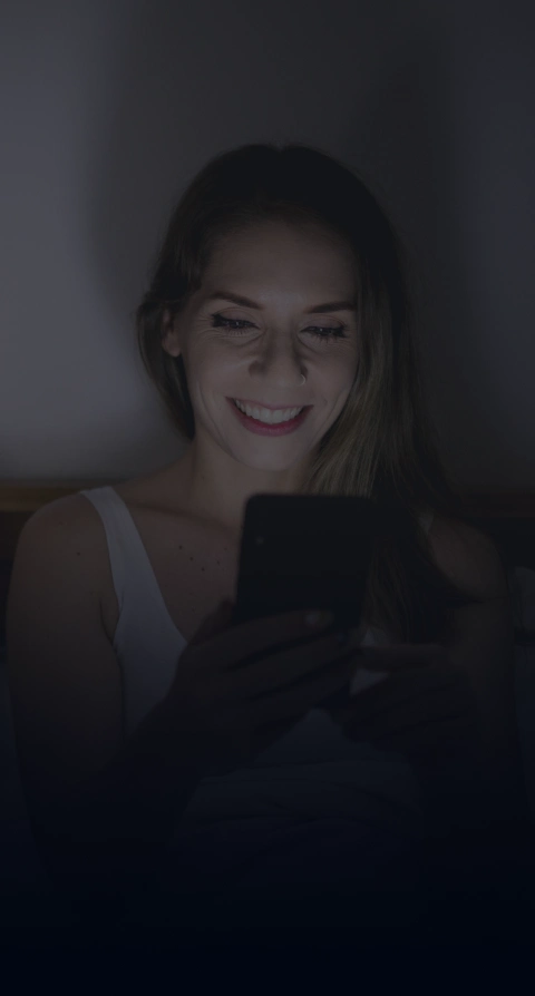 married couple looking at phones in the dark